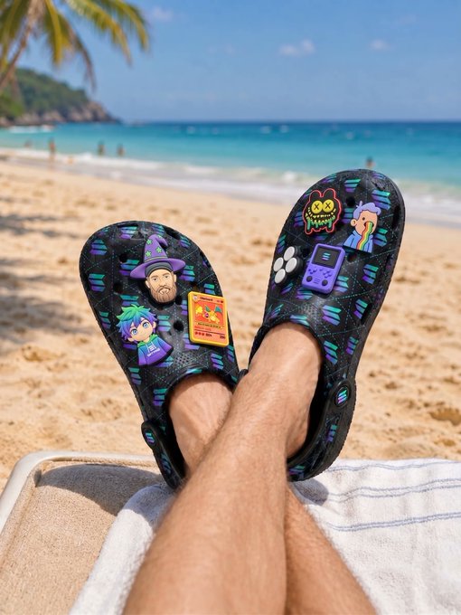 "Solana Summer merch", which means "solana summer" in Spanish, is a line of merchandise created by the popular streaming platform Netflix. The merchandise includes t-shirts, hoodies, mugs, and other accessories featuring the Netflix logo or the show's title. In this image, we see a pair of black Crocs with cartoon characters on them, which are part of the Netflix merchandise collection. These shoes can be seen resting on a towel at the beach, suggesting that someone is enjoying their time by the ocean while wearing these unique and stylish footwear pieces.