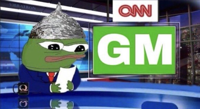 A Pepe the Frog news anchor wearing a tinfoil hat sits at a CNN-style desk beside a large screen displaying the letters 'GM'.