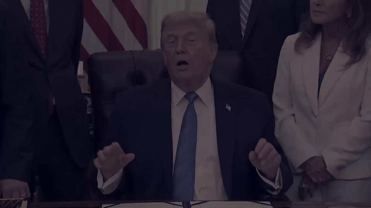 The image shows a man sitting at a desk, wearing a suit and tie, and speaking into a microphone while seated behind a table. The surrounding people appear to be watching him closely or waiting for his speech. The text "Such a common sense game. Focus on the digital assets that are solidified as commodities in the Clarity Act then cross reference that with which ones have CME futures." suggests that there might be an event related to cryptocurrency, specifically Ripple, taking place at this location. The man's attire and the presence of other people indicate that it could be a formal or semi-formal gathering where discussions about financial markets and their trends are being addressed.