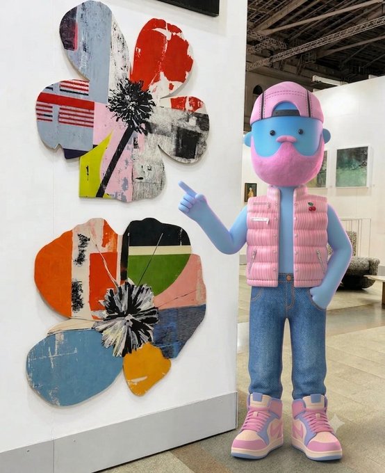 A blue-skinned character wearing a pink cap, pink puffer vest, and pink high-top sneakers stands pointing at two large, colorful flower-shaped mixed-media artworks displayed on a gallery wall, visually embodying the post's message about fragmented pieces coming together as meaningful art.
