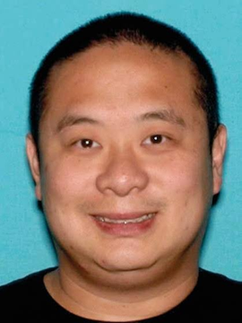 The image shows a headshot-style photograph of a smiling middle-aged man with short dark hair, set against a teal background, which appears to be a photo of Greg Lui—the California tech executive referenced in the post who was allegedly arrested for smuggling Nvidia servers containing H100 chips to China.
