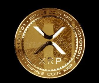 A close-up of a gold Ripple (XRP) commemorative coin featuring the XRP logo and 'RIPPLE COIN XRP' text engraved around its edge against a black background.