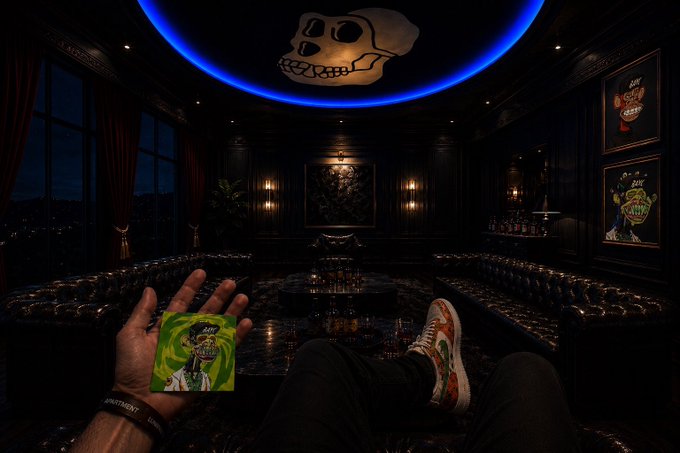 A first-person view of someone holding a card in a dark luxurious lounge with a glowing blue skull logo on the ceiling.