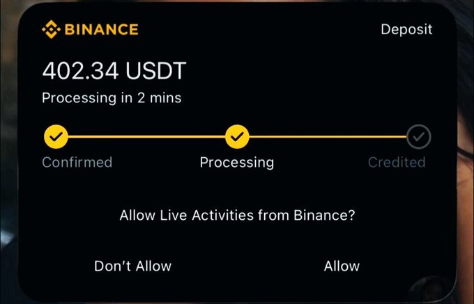 A Binance app screenshot shows a deposit of 402.34 USDT currently processing, with the "Confirmed" and "Processing" steps checked and "Credited" still pending, alongside a prompt asking "Allow Live Activities from Binance?" The image supports the post by displaying the sender's Binance wallet with sufficient funds to give away $200 to two lucky people.