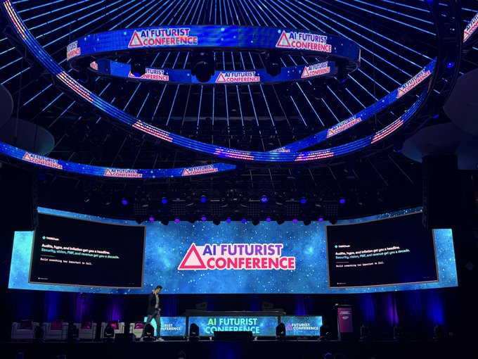 The AI Futurist Conference stage featuring a large screen displaying the 'AI Futurist Conference' logo with circular overhead screens and cosmic-themed blue lighting.