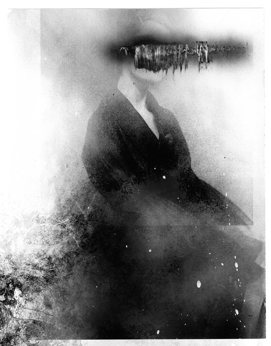 A dark, abstract, vintage-style black-and-white image showing a blurred figure in dark clothing with a heavily distorted or obscured face, set against a hazy, textured background.