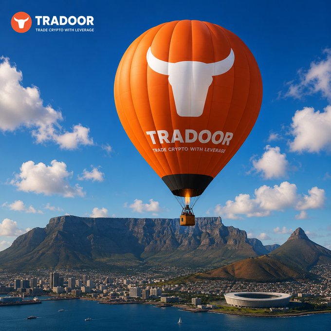 Promotional advertisement for Tradoor showing an orange hot air balloon with a bull logo and 'TRADE CRYPTO WITH LEVERAGE' text floating over Cape Town with Table Mountain and a stadium visible below.
