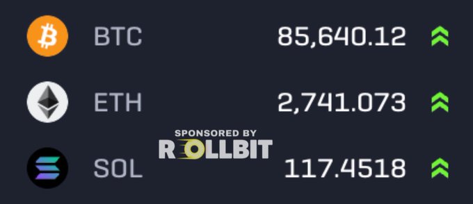 A cryptocurrency price ticker showing BTC at 85,640.12, ETH at 2,741.073, and SOL at 117.4518 with upward green arrows, sponsored by Rollbit.