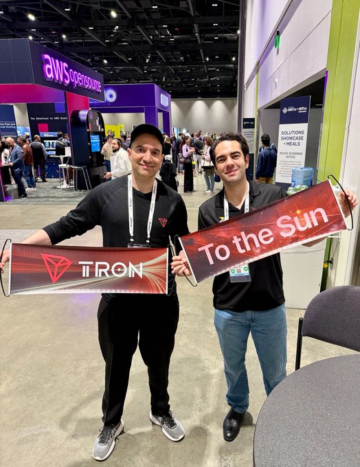 Sam Elfa, TRON DAO Community Spokesperson, stands with another attendee holding signs reading “TRON” and “To the Sun” at AGNTCon + MCPCon North America in San Jose.