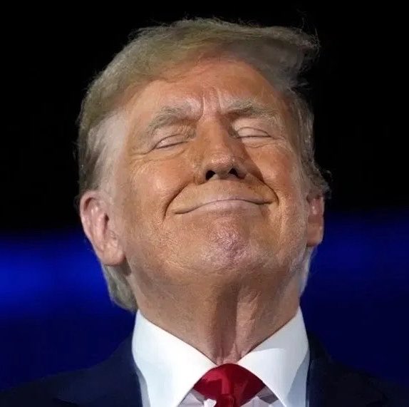 Donald Trump, eyes closed and smirking slightly, is shown in a close-up portrait wearing a red tie against a dark blue background. The image accompanies a post about a potential Trump-associated cryptocurrency launch, with on-chain preparations spotted involving 300 ETH and test tokens on the Robinhood network.