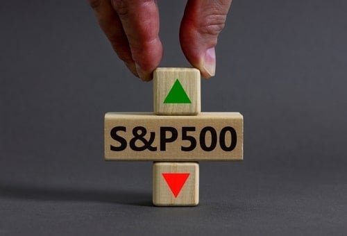 A conceptual stock photo showing a hand stacking wooden blocks displaying 'S&P500' with a green up arrow and a red down arrow against a gray background.