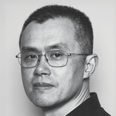 Black and white portrait photograph of an Asian man wearing glasses and a dark shirt against a plain background.