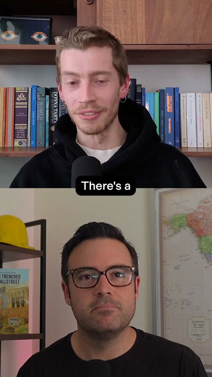 In the image, there are two men standing side by side, both wearing black shirts with glasses. One man's head is slightly tilted towards a camera while he talks, while his companion looks at something outside of the frame. The background features multiple books arranged on shelves and a map hanging on the wall behind them. The caption provided about NFTs teaches us that art looks better when its price is high. This can be related to the image as it might symbolize how certain artworks or books become more valuable due to their rarity, uniqueness, or historical significance, potentially making them desirable for collectors or enthusiasts who are willing to pay a premium for such items.