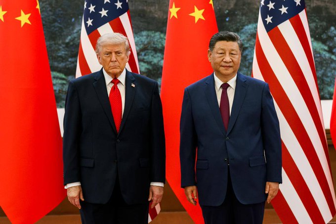US President Donald Trump and Chinese President Xi Jinping stand together, symbolizing the ongoing trade discussions between the two nations. The image depicts the leaders of the US and China, whose upcoming summit is relevant to the expected delay of new excess-capacity tariffs.