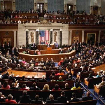 The image shows a packed session of the U.S. House of Representatives, with members of Congress gathered in the chamber beneath an American flag, while a speaker stands at the podium addressing the assembly. This setting reflects the legislative context of the post, which references Senator Elissa Slotkin's criticism of the CLARITY Act's ethics provisions, including concerns about crypto-related conflicts and the CFTC's regulatory authority.