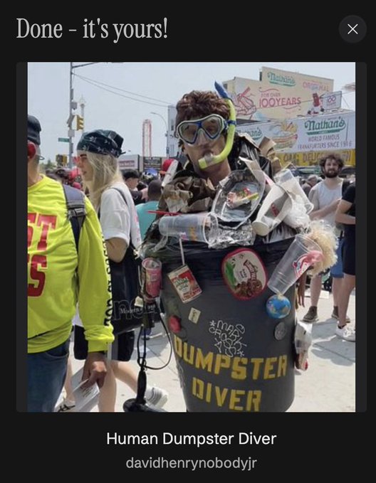 A person dressed as a 'Human Dumpster Diver' at Coney Island, wearing snorkeling goggles and covered in trash, sitting in a trash bin labeled 'DUMPSTER DIVER'. A Nathan's hot dog sign reads 'CELEBRATING 100 YEARS' and 'Nathan's WORLD FAMOUS 1.6 HOT DOGS SINCE 1916'.