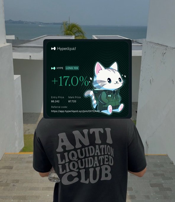 A person wearing an 'ANTI LIQUIDATION LIQUIDATED CLUB' t-shirt stands facing the ocean, with a Hyperliquid trading card showing HYPE LONG 10X at +17.0% gain.