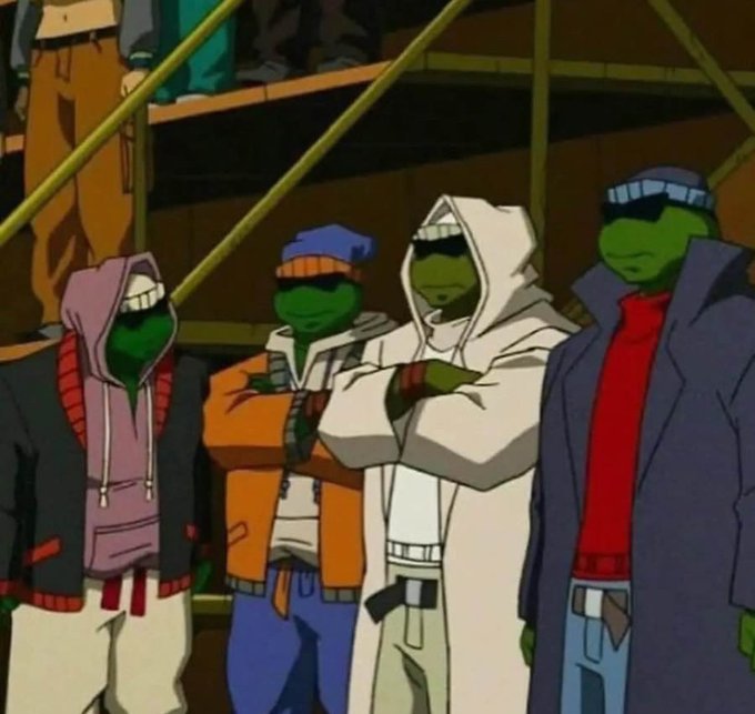 A screenshot from an animated Teenage Mutant Ninja Turtles show showing four green turtle characters in hoodies and jackets with their arms crossed, looking unimpressed.