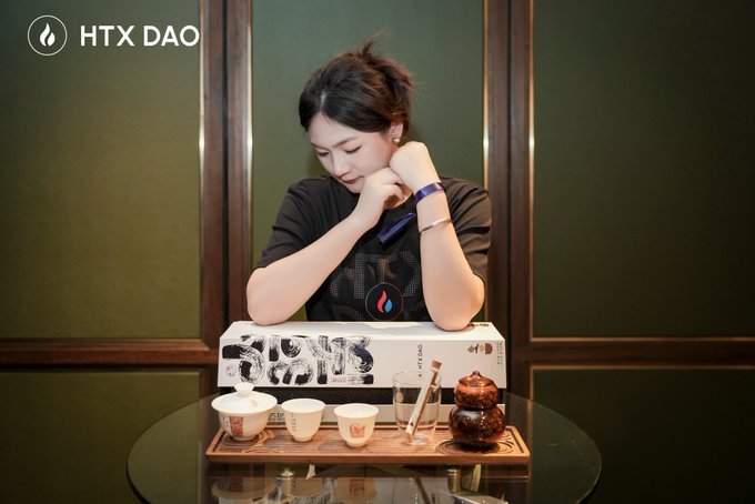 A woman leans over a tea set with a box labeled 'SAPA' and 'HTX ĐẠO' in a promotional image.