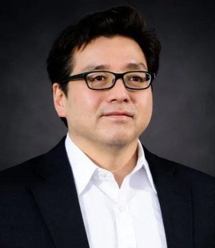A professional headshot of a man wearing glasses and a dark blazer over a white shirt, presumably Tom Lee of BitMine Immersion Technologies, whose firm recently made headlines for accumulating $14.2M worth of ETH, bringing its holdings to $11.14B or approximately 4.8% of Ethereum's total supply.