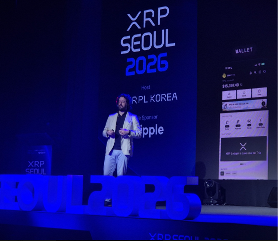 A man stands on stage at the XRP Seoul 2026 conference, hosted by XRPL Korea with sponsor Ripple, next to a large screen displaying a wallet interface showing $15,262.48.