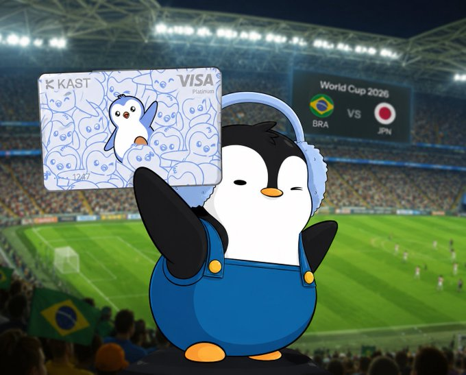 A cartoon penguin wearing headphones holds up a KAST Visa Platinum card featuring penguin designs, set against a World Cup 2026 stadium backdrop showing a Brazil vs Japan matchup.