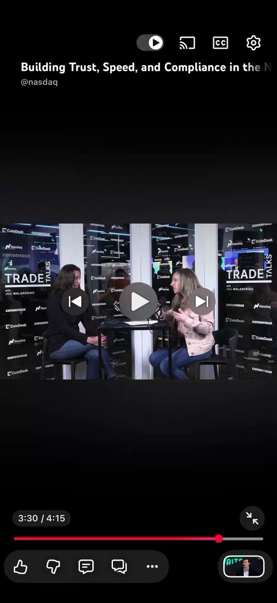 The image shows a person watching an interview on a streaming platform with another person sitting next to them, likely in front of a television or screen. They are discussing the topic of building trust, speed, and compliance in business operations.