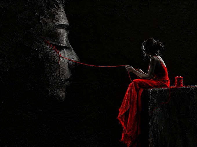 A dark, surreal artwork depicting a woman in a flowing red dress sitting on a ledge, sewing red thread across the stitched-shut mouth of a giant shadowy face.
