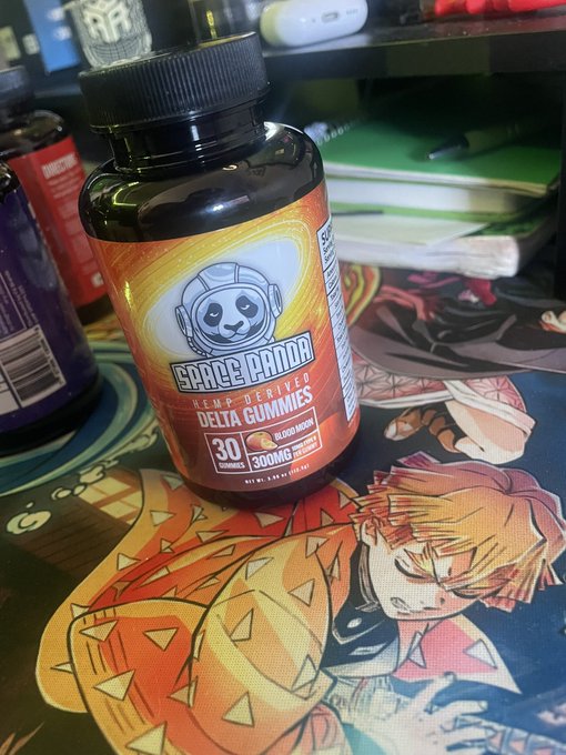 A bottle of "Space Panda Hemp-Derived Delta Gummies" in Blood Moon flavor (300MG, 30 gummies) sitting on an anime-themed mousepad.