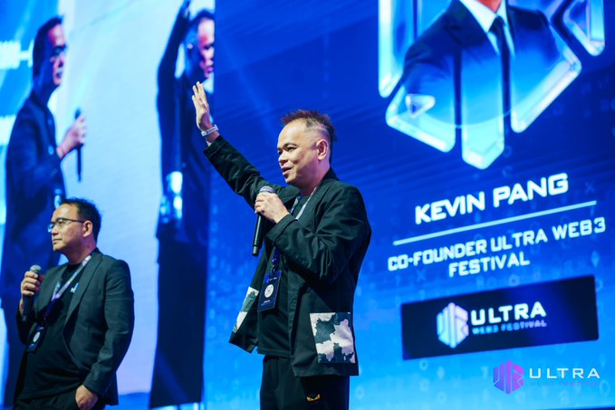 Kevin Pang, co-founder of Ultra Web3 Festival, takes the stage alongside his co-founder to deliver the opening speech at the inaugural Ultra Web3 Festival in Kuala Lumpur, with his name and title prominently displayed on the large screen behind him as he welcomes speakers and delegates.