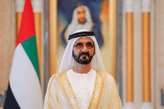 The image shows a bearded man wearing traditional Arab attire (white kandura and ghutra headdress) standing in front of the UAE flag and what appears to be a portrait of a royal figure in an ornate interior. The caption relates to the post about the UAE reportedly holding $760 million worth of Bitcoin in its national reserves, depicting what appears to be a UAE royal or government official, suggesting a formal connection between the UAE leadership and the reported cryptocurrency reserves.