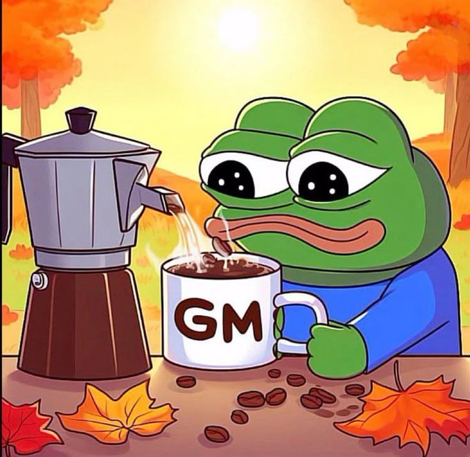 A cartoon Pepe the Frog in a blue shirt drinks coffee from a mug labeled 'GM' while a moka pot brews beside him, set against an autumn backdrop with falling leaves.
