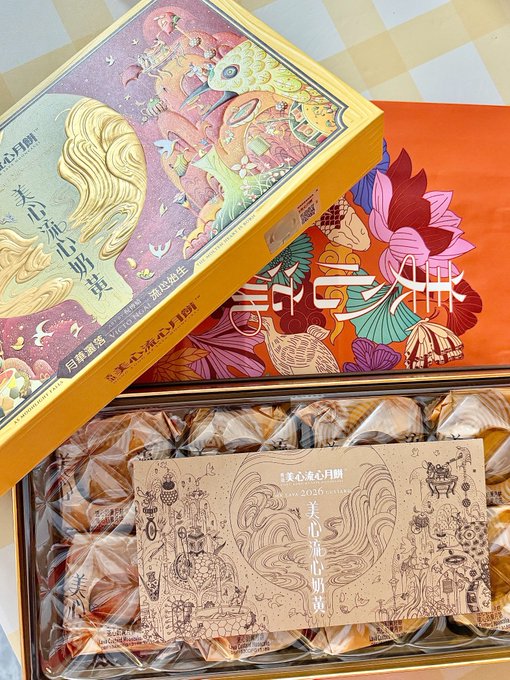 A beautifully illustrated box of "美心流心月餅" (Maxim's lava custard mooncakes) is displayed with its decorative lid partially open, revealing individually wrapped golden treats inside. The accompanying post invites followers to leave comments in exchange for a Mid-Autumn Festival blessing, fittingly showcasing these traditional mooncakes as a festive symbol.
