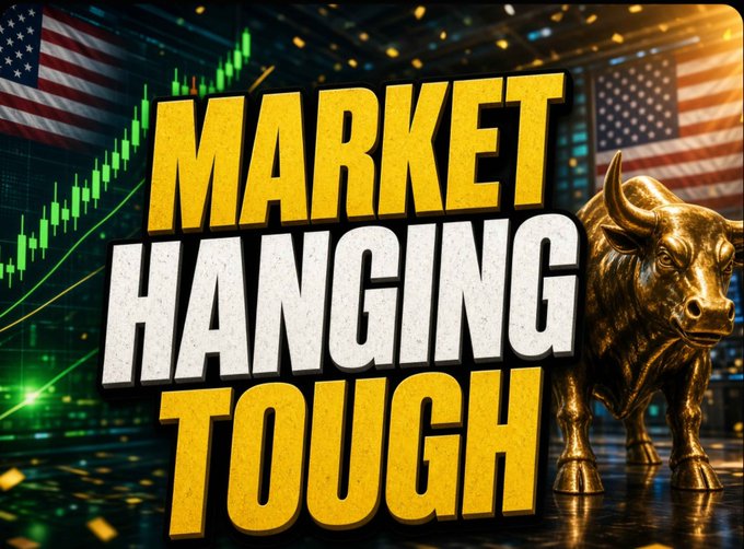 A stock market thumbnail featuring the bold yellow text 'MARKET HANGING TOUGH' alongside a golden bull statue, an American flag, and green candlestick charts indicating a rising market.