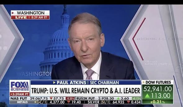 A Fox Business news broadcast featuring SEC Chairman Paul Atkins, with on-screen text reading 'WASHINGTON LIVE 8:39 AM ET,' 'TRUMP: U.S. WILL REMAIN CRYPTO & A.I. LEADER,' and Dow futures listed at 52,941.00.