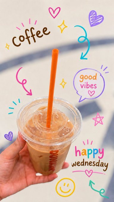 A hand holds an iced coffee in a clear plastic cup with an orange straw, decorated with colorful doodles and text including 'coffee', 'good vibes', and 'happy wednesday'.