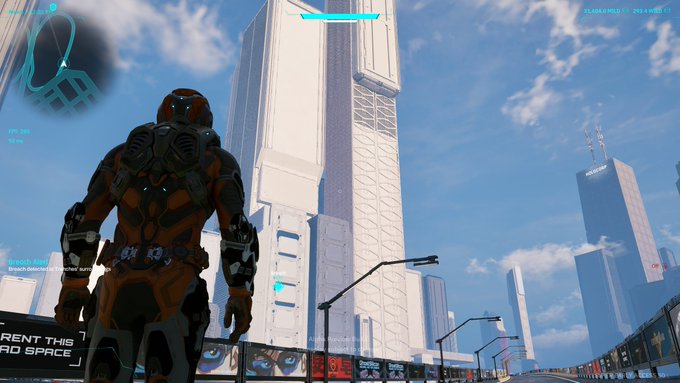 An armored figure in an orange and black suit stands overlooking a futuristic cityscape with towering skyscrapers, including one prominently labeled "WILDER," capturing the vast scale and immersive atmosphere of the Wilder World virtual environment.