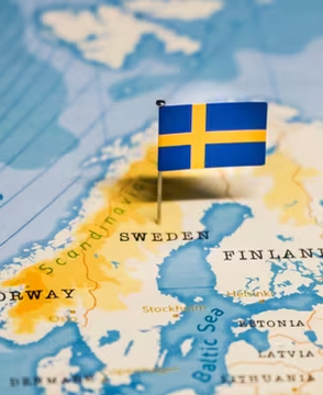 A Swedish flag pin is placed on a map highlighting Sweden and its surrounding Scandinavian neighbors, including Norway, Finland, Estonia, and Latvia, with the Baltic Sea labeled. The image visually represents the Swedish government's tax dispute with crypto miners, specifically its $56M demand from companies like HIVE's local unit.