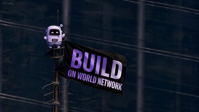 A small white robot figure stands atop a pole next to a large banner reading "BUILD ON WORLD NETWORK," visually reinforcing the message that World Network verifies users and lets them build, explore, and move.