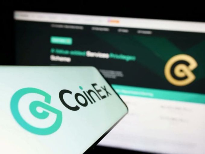 The image shows a smartphone displaying the CoinEx logo and branding, with a blurred computer screen in the background showing the CoinEx website featuring text that reads "5 Value-added Services Strategic" alongside the CoinEx logo. This visual aligns with the accompanying post highlighting CoinEx's reliable platform performance, clean interface, and competitive trading experience.