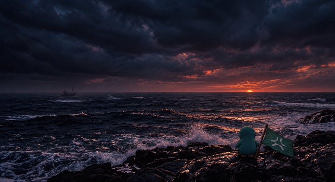 A small blue creature sits on rocky shore holding a green flag, watching a dramatic sunset over the ocean with a ship visible on the horizon.