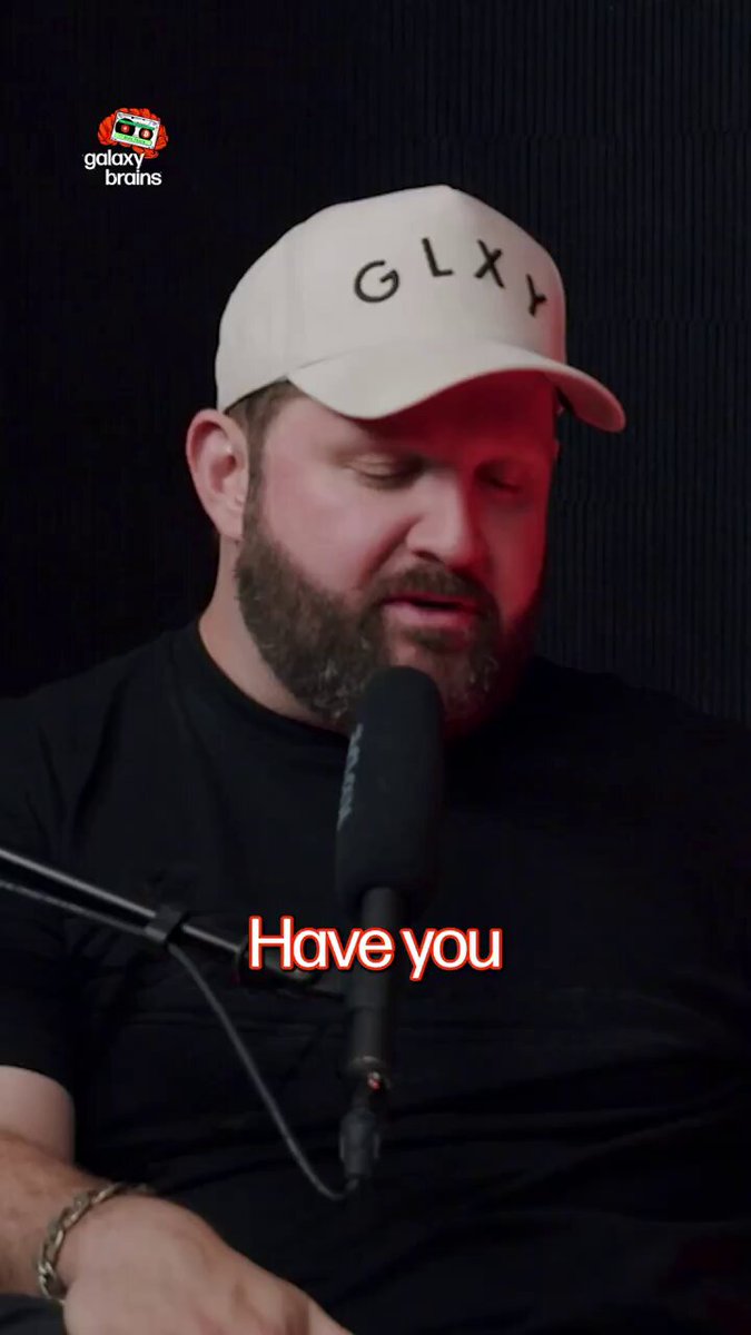 The image features a man wearing a white baseball cap, sitting down with his arm resting on a microphone. The caption of the image reads "CZ: Hyperliquid $HYPE occupies a niche Binance cannot compete in." This suggests that the man is likely discussing or promoting a cryptocurrency called Hyper Liquid.