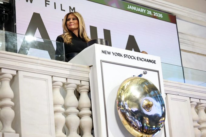 Melania Trump stands at the New York Stock Exchange podium during the "NOW FILM" launch on January 28, 2026, with the iconic brass bell visible in the foreground, hinting at her upcoming film venture.