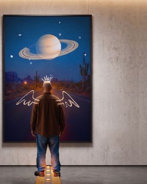 A man stands before a large framed poster depicting a surreal desert nightscape featuring a crown, angel wings, and Saturn beneath a starry sky, with glowing initials "ASH" on the floor beneath his feet—matching the "Ego Trip" artwork promoted by contemporary artist ASHUZ. The scene captures the act of contemplating the artwork, highlighting key mystical elements like the royal crown and planetary ring as focal points.