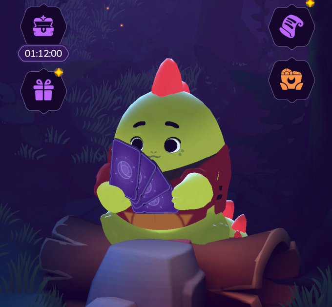 A cute green cartoon dragon-like character with red spikes sits on a treasure chest holding purple cards in a nighttime forest setting, with UI icons showing a timer at 01:12:00 and various game items.