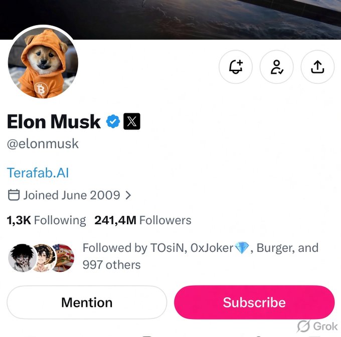 A profile screenshot of an X (formerly Twitter) account for Elon Musk (@elonmusk) featuring a Shiba Inu dog avatar in an orange Bitcoin hoodie, showing 241.4M Followers, a 'Terafab.AI' link, and a pink Subscribe button.