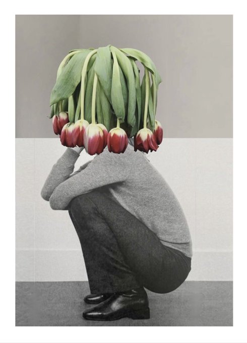 An artistic photograph of a crouching person wearing a flower bouquet instead of a head, obscuring their face.