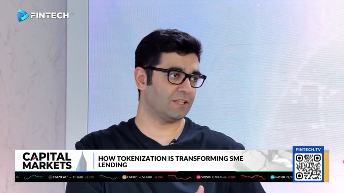 A man with glasses appears on a "FINTECH.TV" broadcast of "CAPITAL MARKETS," discussing "HOW TOKENIZATION IS TRANSFORMING SME LENDING," with stock tickers for DJ, EGX30, SPX, and NASDAQ visible at the bottom.