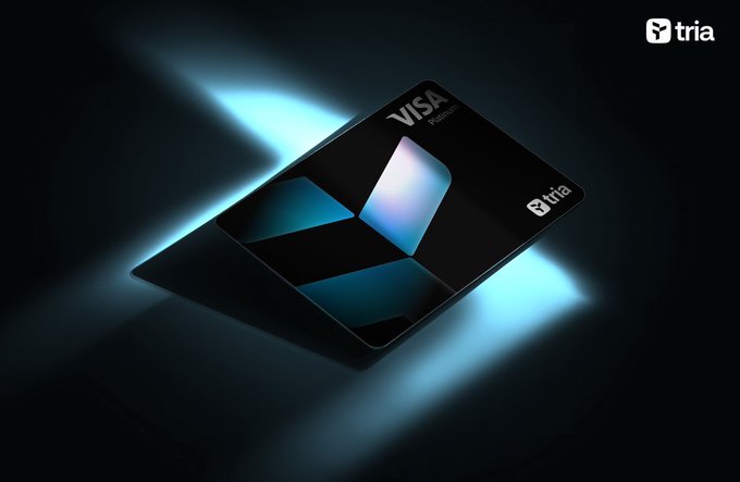 A sleek black Tria Visa Premium credit card is illuminated by a striking blue spotlight against a dark background. The card's design reflects Tria's positioning as a versatile onchain financial tool that lets everyday users hold, trade, and spend with ease.