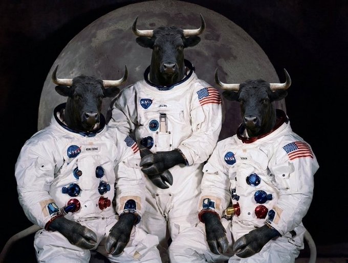 Surreal image of three NASA astronauts in spacesuits with black bull heads, posed in front of the moon.